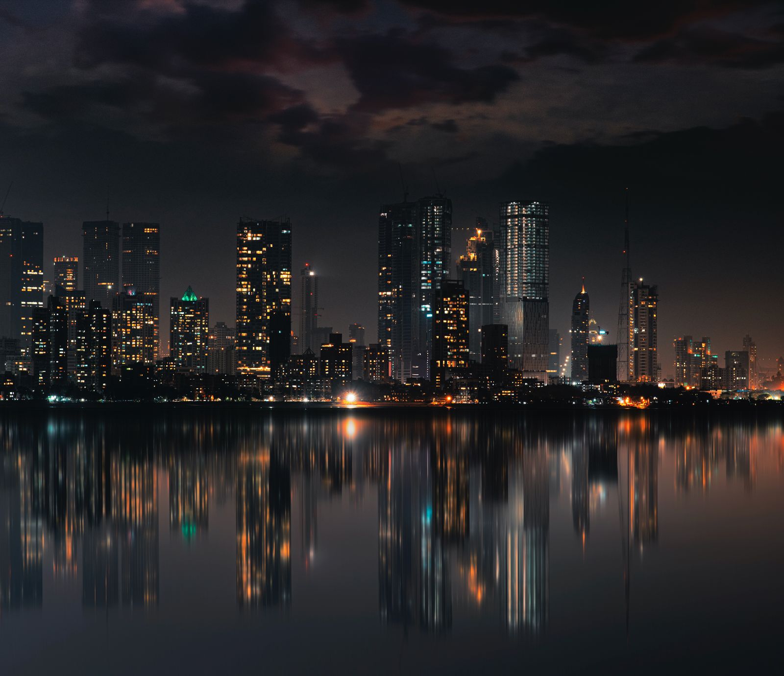 The Mumbai skyline at night, reflected in water